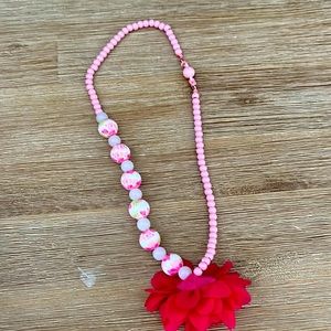 Pink floral necklace with a flower in the side and it’s for baby girls OS